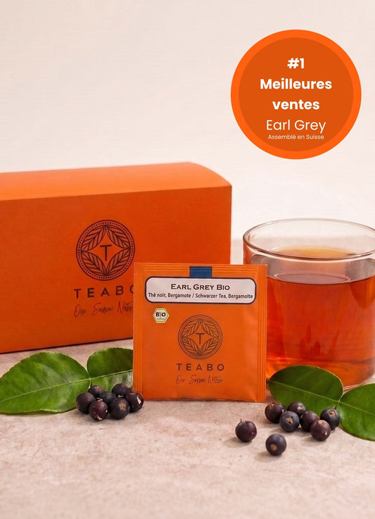 Earl Grey BIO, meilleure vente : la boîte, un sachet pyramide et une tasse de thé ambré